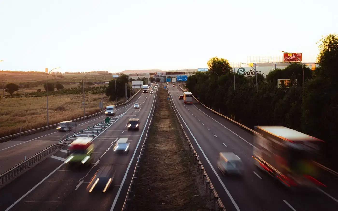 Benzi de autostradă la amurg, cu autovehicule în mișcare